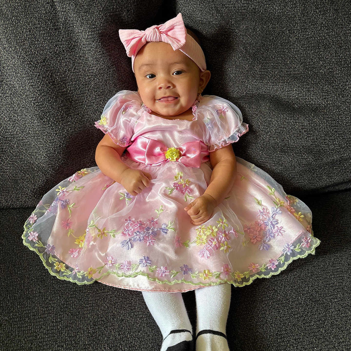 Vivianna joined the competition — help win amazing prizes! baby, child, girl, dress, pink_dress, headband, bow, smile, tongue_out, sitting, couch, fabric, floral, stockings, socks, happy, portrait, indoor, cute, person