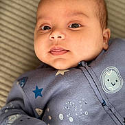 Amir participe au concours pour gagner de l'argent avec cette photo : baby, infant, face, close_up, blue_clothing, stars, moon, sleepwear, cute, lying_down, child, soft_background, portrait, young_child, cozy, expression, skin, eyes, mouth, hand