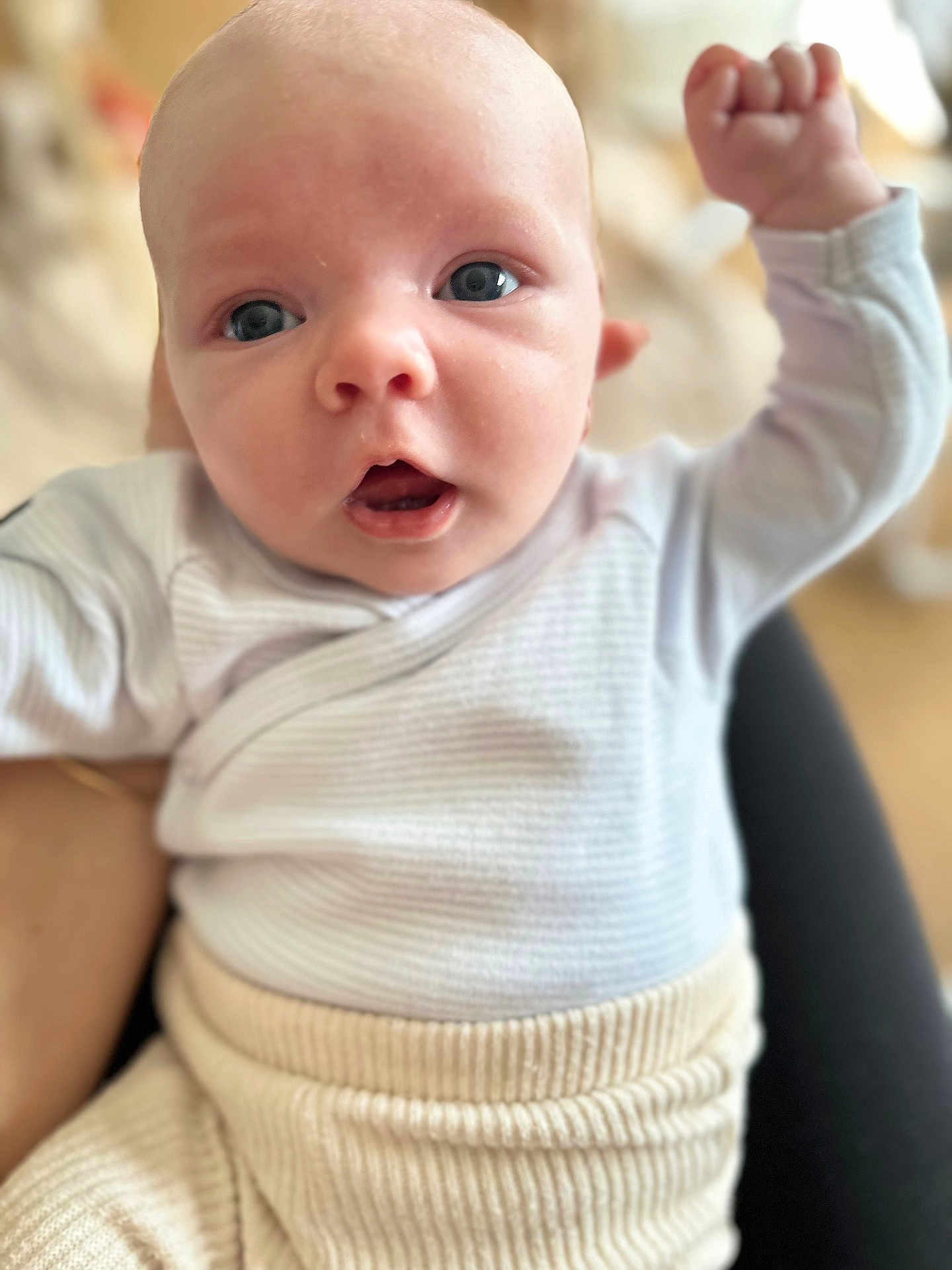Aaron participe au concours pour gagner de l'argent avec cette photo : baby, infant, face, arm, clothing, white, beige, closeup, expression, person, cute, young, child, skin, eyes, mouth, raised_arm, soft_focus, indoors, portrait