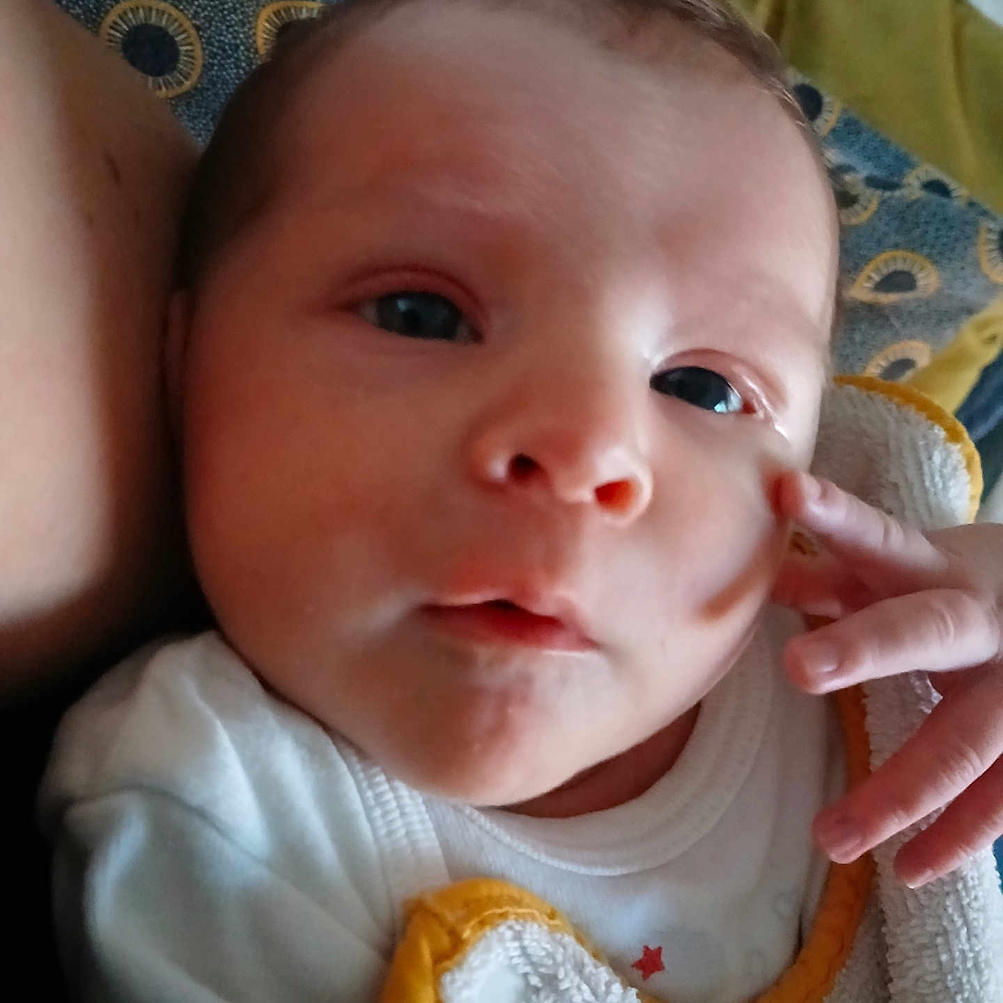 Liv a rejoint le concours — aidez-le/la à gagner de superbes lots ! baby, child, close_up, cute, expression, face, gaze, hand, head, indoor, infant, newborn, patterned_pillow, portrait, resting, skin, soft_lighting, towel, white_clothing, yellow_trim