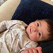 Essex is registered to the contest to win money with this photo: baby, infant, onesie, pajamas, moon, stars, pillow, couch, hand, holding, eyes, smile, cheeks, hair, closeup, portrait, indoor, fabric, relaxed, cozy
