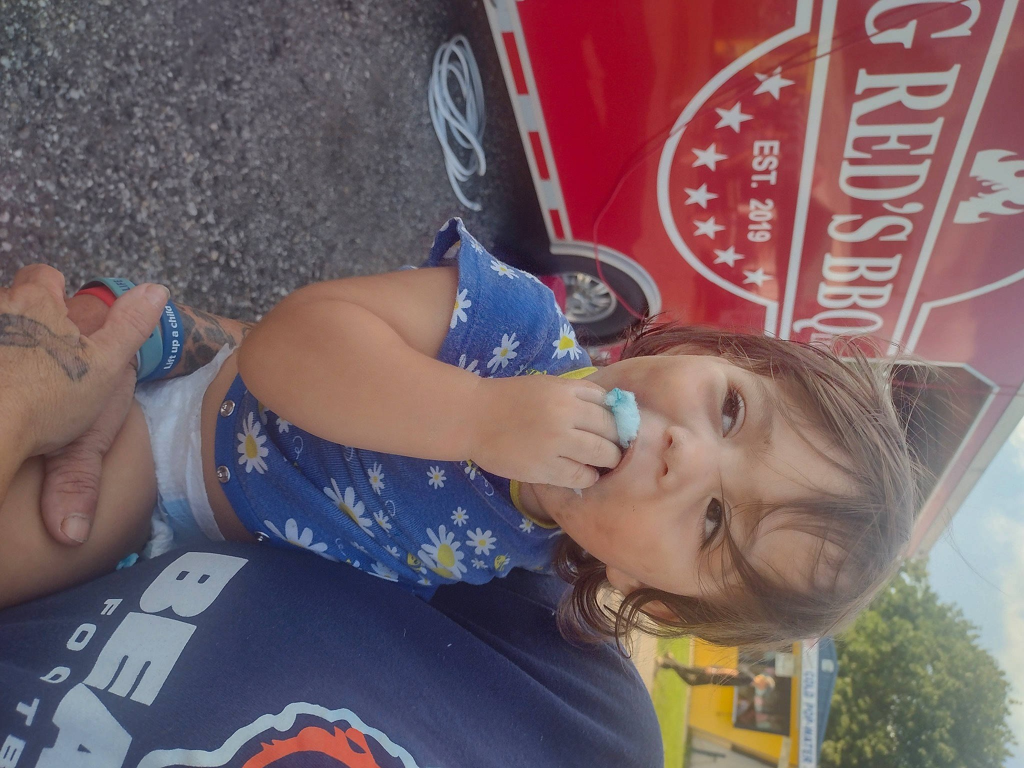 Daniella is registered to the contest to win money with this photo: automotive_tire, car, child, electric_blue, fun, happy, hat, leisure, logo, person, recreation, t_shirt, tire, toddler, tree, vacation, vehicle, wheel