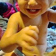 Frederick is registered to the contest to win money with this photo: baby, blanket, child, closeup, cozy, cute, diaper, expression, face, hand, happy, indoor, infant, person, playful, sitting, skin, smile, toddler, young_child