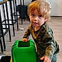 Frederick joined the competition — help win amazing prizes! candid, casual, child, clothing, curious, floor, furniture, green, indoor, mess, messy_face, person, play, room, steering_wheel, toddler, toy, vehicle, wooden_floor, young_child