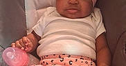 Samanii is registered to the contest to win money with this photo: baby, car_seat, child, clothing, comfort, cute, expression, face, headband, holding, indoors, infant, infant_toddler, leopard_print, pants, pink_bottle, pink_bow, seated, socks, white_shirt