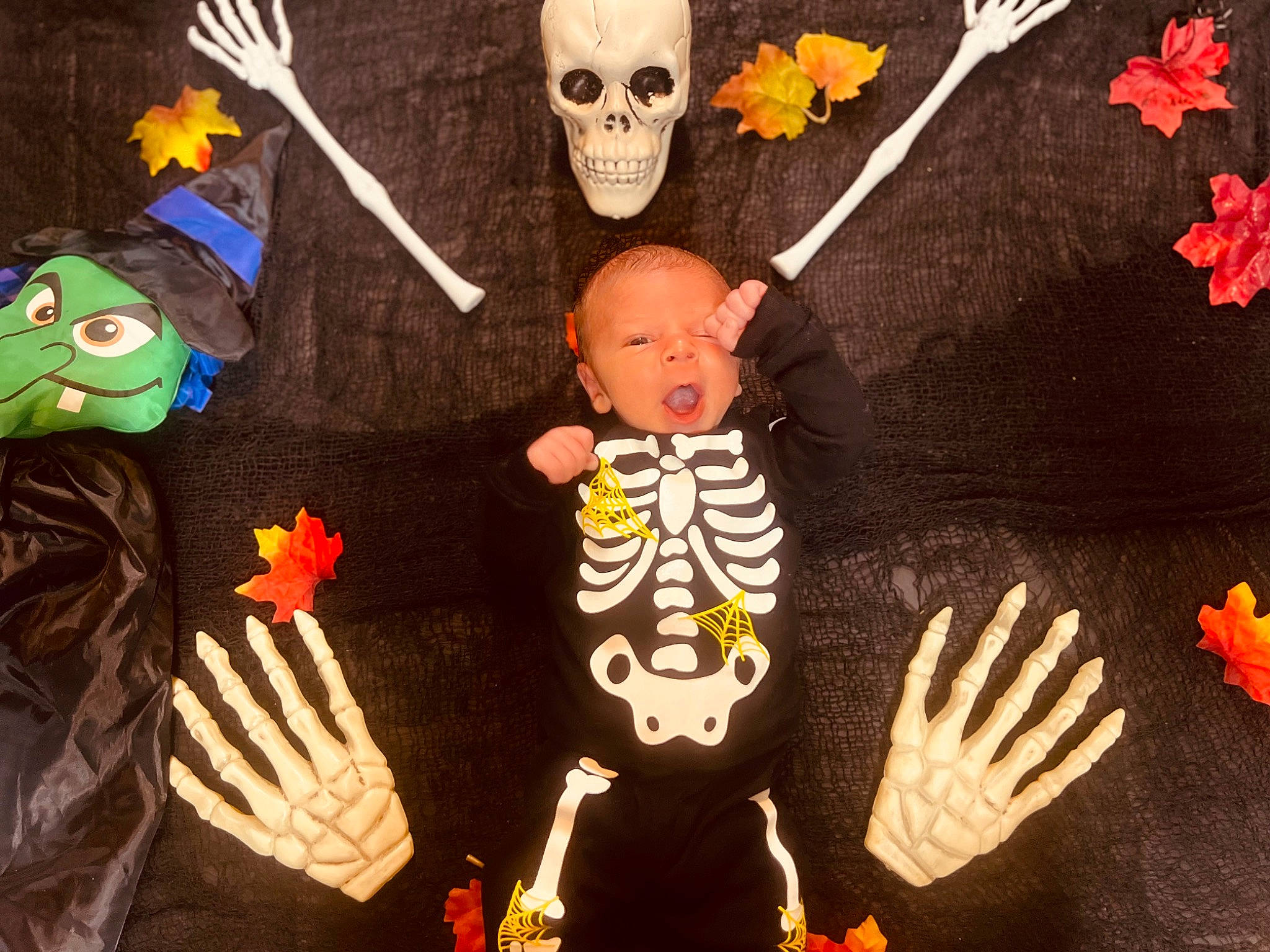 Caleb is registered to the contest to win money with this photo: art, bone, costume, event, fictional_character, finger, fun, gesture, green, hand, happy, hat, headgear, mask, orange, person, skeleton, skull, t_shirt, visual_arts