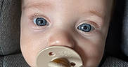 Sterling joined the competition — help win amazing prizes! baby, blue_eyes, pacifier, car_seat, child, face, close_up, infant, cute, adorable, young_child, clothing, strap, beige, plastic, expressionless, person, childhood, indoor, portrait