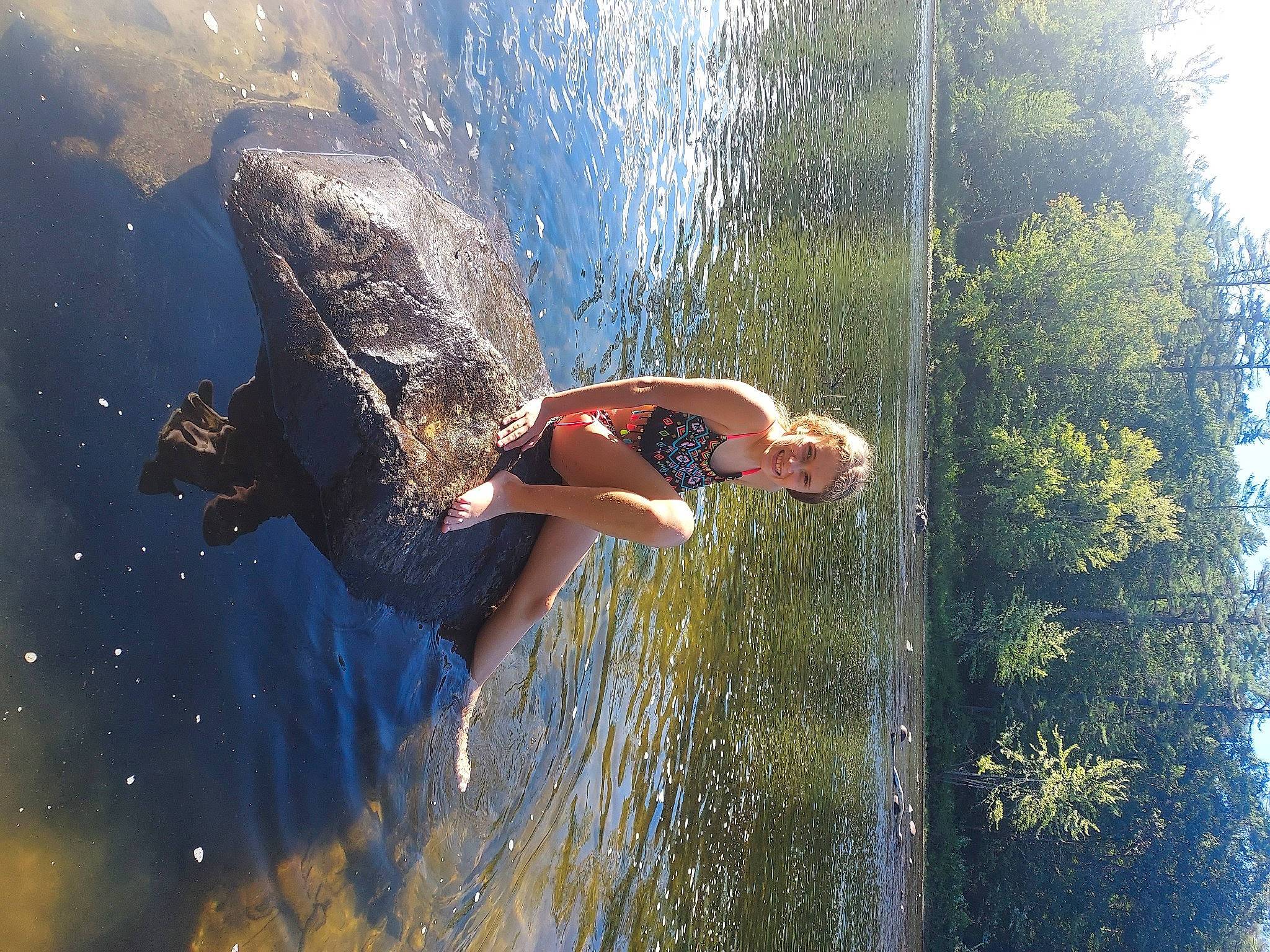 Valentina is registered to the contest to win money with this photo: body_of_water, fun, grass, happy, joy, lake, leisure, people_in_nature, person, personal_protective_equipment, recreation, reflection, shorts, sky, sunglasses, sunlight, tree, vacation, water, water_feature