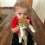 Millie joined the competition — help win amazing prizes! toddler, child, kitten, cat, red_shirt, curly_hair, wooden_floor, indoor, holding, pet, animal, young_child, home, door, rug, flooring, cute, blond_hair, curious, sitting