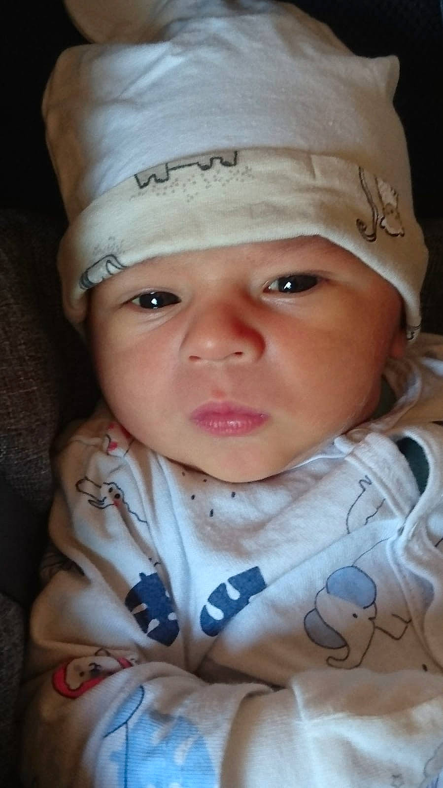 Victor participe au concours pour gagner de l'argent avec cette photo : baby, baby_toddler_clothing, cap, cheek, child, comfort, eye, eyelash, face, fashion_accessory, happy, hat, headwear, iris, lip, person, portrait_photography, sitting, skin, sleeve