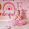 baby, birthday, blue_eyes, celebration, child, crown, curious, cute, decorations, dress, festive, heart, indoor, infant, pink, portrait, rainbow, sitting, tutu_dress, white_blanket