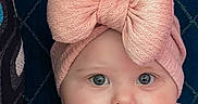 Lainey joined the competition — help win amazing prizes! baby, blue_eyes, child, close_up, clothing, cushion, cute, fabric, face, headband, indoor, infant, newborn, pattern, person, pink_bow, portrait, smile, soft_texture, young_child