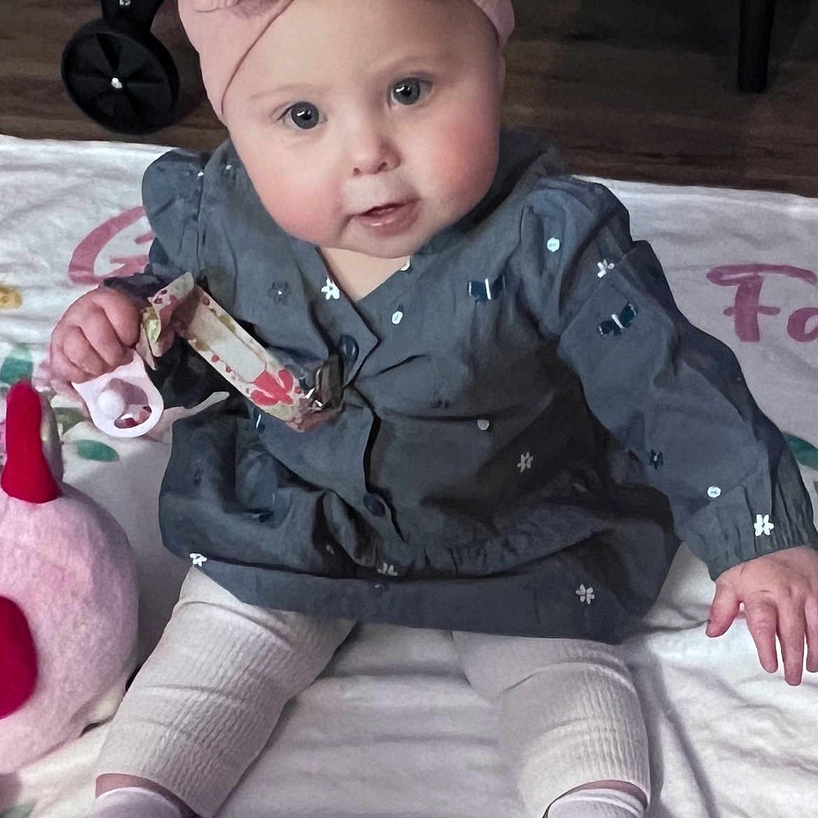 Lainey joined the competition — help win amazing prizes! baby, child, infant, headband, pink, dress, toy, blanket, sitting, floor, indoor, curious, cute, chubby_cheeks, socks, soft_toys, home, flooring, person, portrait