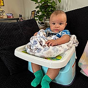 Kisean joined the competition — help win amazing prizes! baby, child, infant, blanket, baby_seat, socks, couch, plant, indoor, home, furniture, portrait, person, face, green_socks, patterned_blanket, cozy, casual, seated, cute