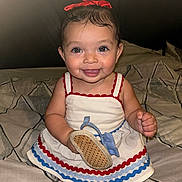 Gianna joined the competition — help win amazing prizes! baby, child, smiling, dress, bow, bed, indoor, happy, holding, footwear, cute, person, portrait, young, fashion, accessory, sitting, infant, clothing, pattern