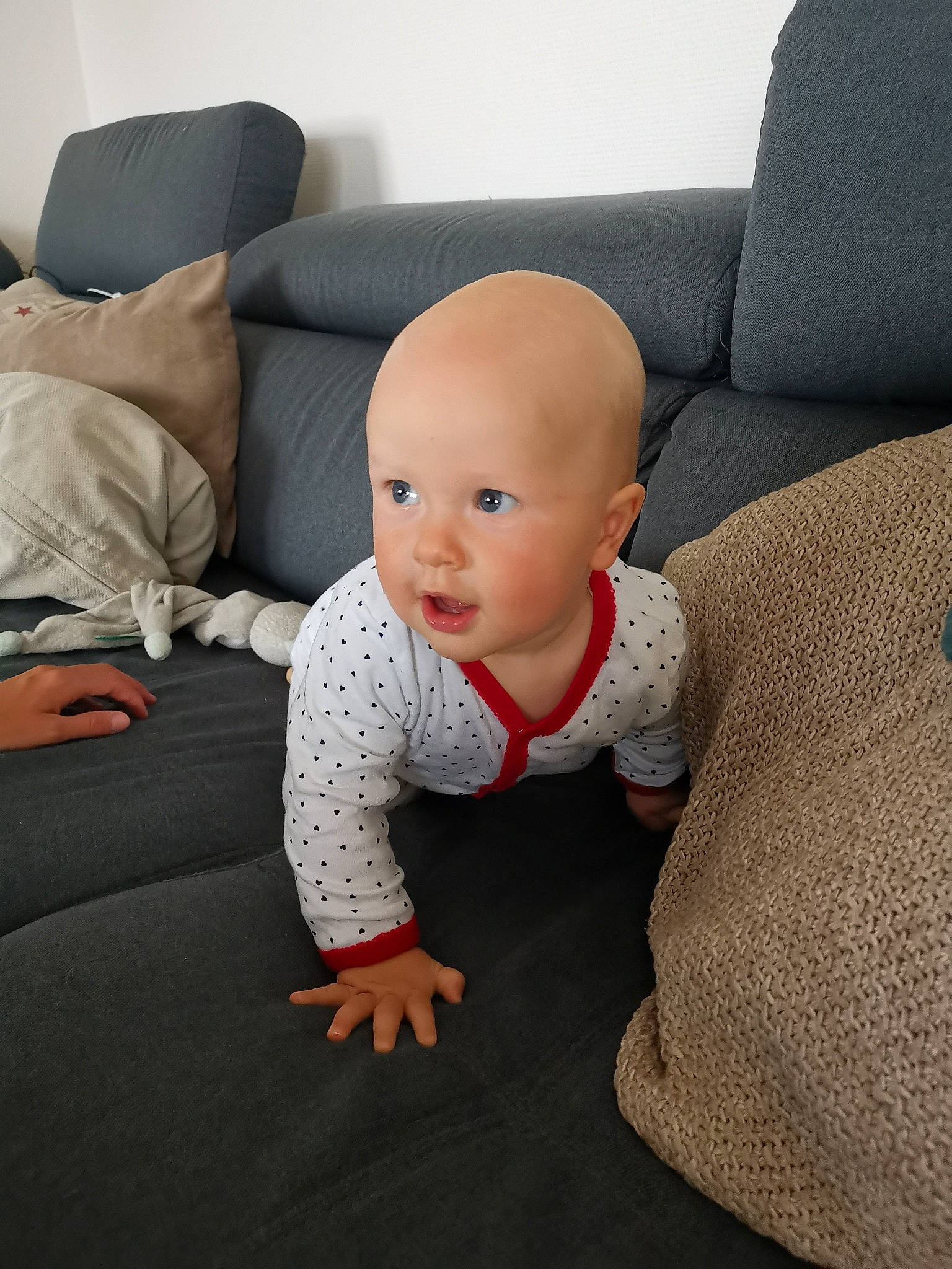 Baptiste a rejoint le concours — aidez-le/la à gagner de superbes lots ! baby, baby_toddler_clothing, carmine, comfort, couch, eye, face, floor, flooring, grey, head, knee, linens, person, sitting, sleeve, stuffed_toy, t_shirt, toddler, toy