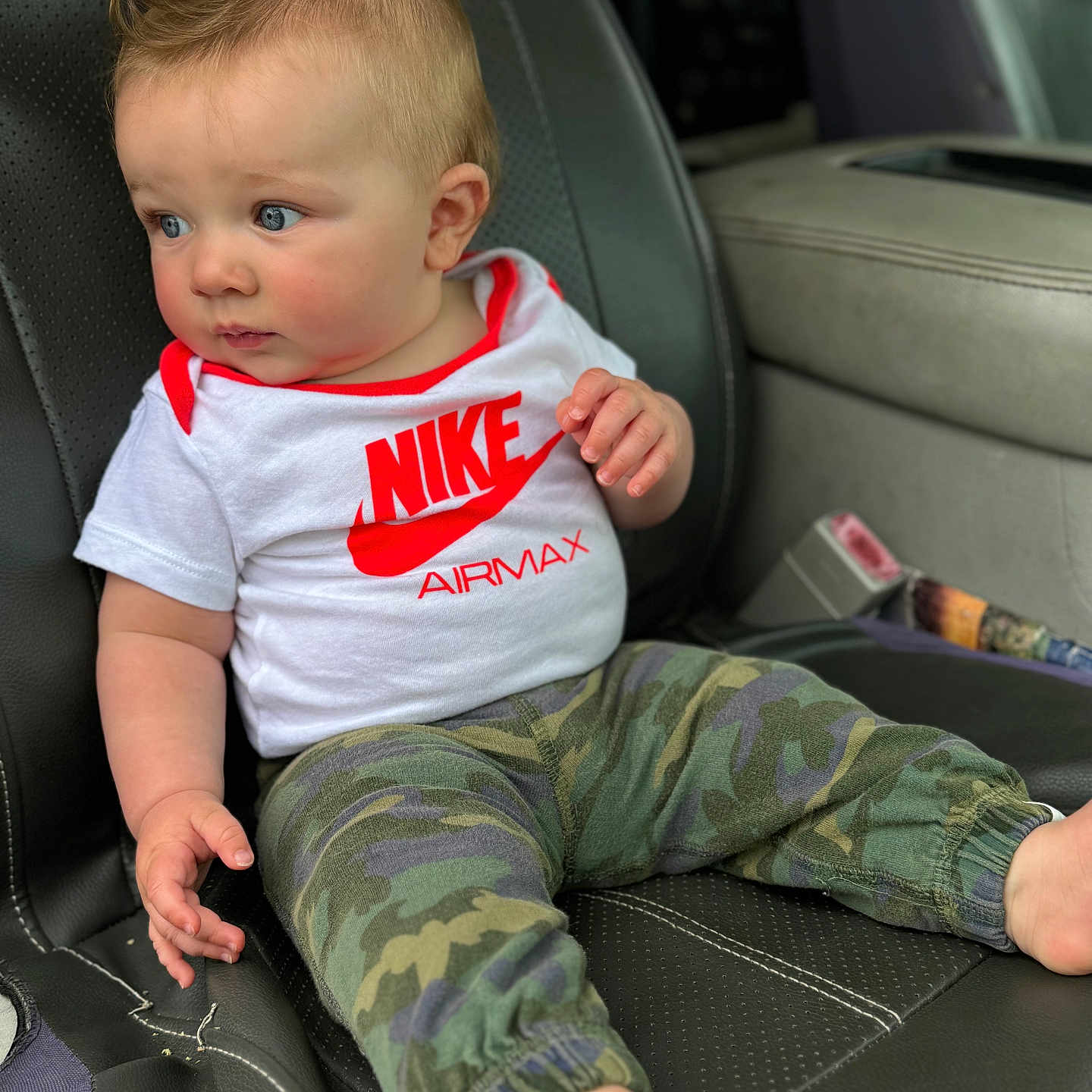 Bentley is registered to the contest to win money with this photo: accessories, baby, belt, bodypart, clothing, couch, cushion, face, finger, furniture, hand, head, homedecor, pants, person, shorts, sitting, t_shirt, transportation, vehicle