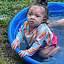 Athena joined the competition — help win amazing prizes! toddler, child, water, pool, outdoor, grass, wet_hair, blue_pool, colorful_clothing, long_sleeve_shirt, pink_shorts, curious_expression, kneeling, nature, summer, play, water_play, young_child, person, daylight
