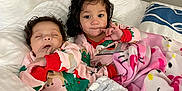 Alayia is registered to the contest to win money with this photo: baby, toddler, child, pajamas, blanket, bed, pillow, lamp, indoor, sleeping, curly_hair, smiling, cozy, cute, holiday_theme, person, furniture, soft, relaxing, home