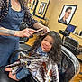 Alayia is registered to the contest to win money with this photo: child, hairdresser, hair_brush, salon_chair, haircut, cape, smile, barefoot, stylist, mirror, portrait, computer, floor, wood_floor, bottle, shelf, person, indoor, hair, clothing