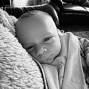 Tom a rejoint le concours — aidez-le/la à gagner de superbes lots ! baby, infant, blanket, pillow, towel, face, skin, person, indoor, leather_sofa, couch, floor_tiles, black_and_white, portrait, closeup, calm, sleepy, soft_texture, comfort, resting