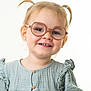 toddler, child, smiling, glasses, pigtails, green_dress, portrait, cute, happy, young_child, face, light_hair, ruffles, buttoned_dress, studio, innocent, fashion, closeup, headshot, eyewear