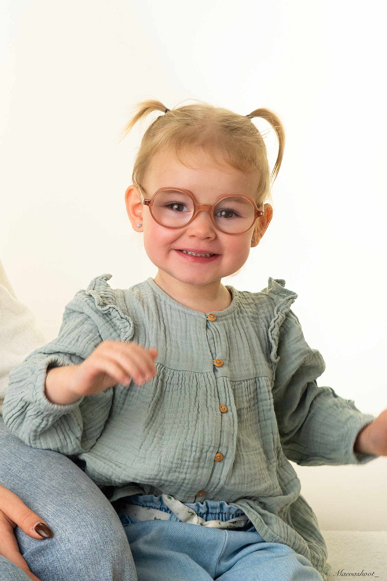 Ambre participe au concours pour gagner de l'argent avec cette photo : toddler, child, glasses, pigtails, smiling, green_blouse, jeans, sitting, happy, portrait, indoor, cute, person, young_child, buttoned_shirt, casual_clothing, fashion, human, face, eyewear