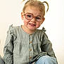 Ambre participe au concours pour gagner de l'argent avec cette photo : toddler, child, glasses, pigtails, smile, green_blouse, blue_jeans, portrait, cute, indoors, sitting, young_child, fashion, casual_clothing, happy, face, person, studio_lighting, buttoned_shirt, light_background