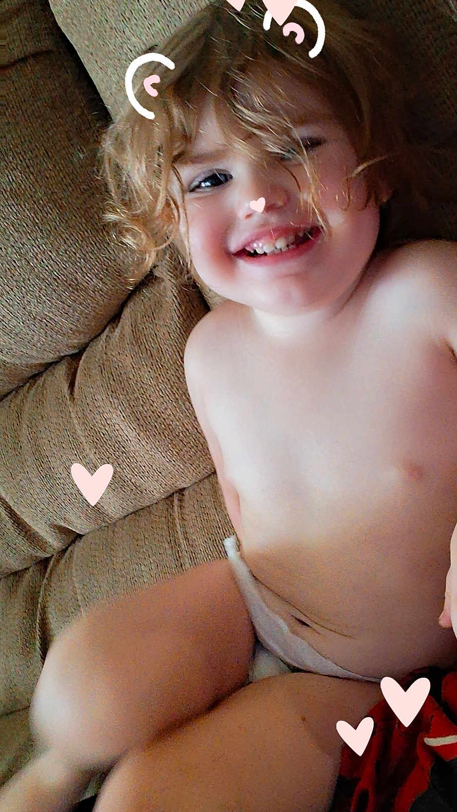 Avery joined the competition — help win amazing prizes! toddler, child, smiling, curly_hair, couch, indoor, happy, face, skin, diaper, playful, heart, doodle, pink, casual, relaxing, portrait, closeup, seat, cute