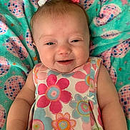 Adilynn joined the competition — help win amazing prizes! baby, child, smiling, pigtails, bows, dress, floral_pattern, blanket, pastel_colors, happy, cute, infant, lying_down, soft_texture, indoors, closeup, skin, face, person, comfort