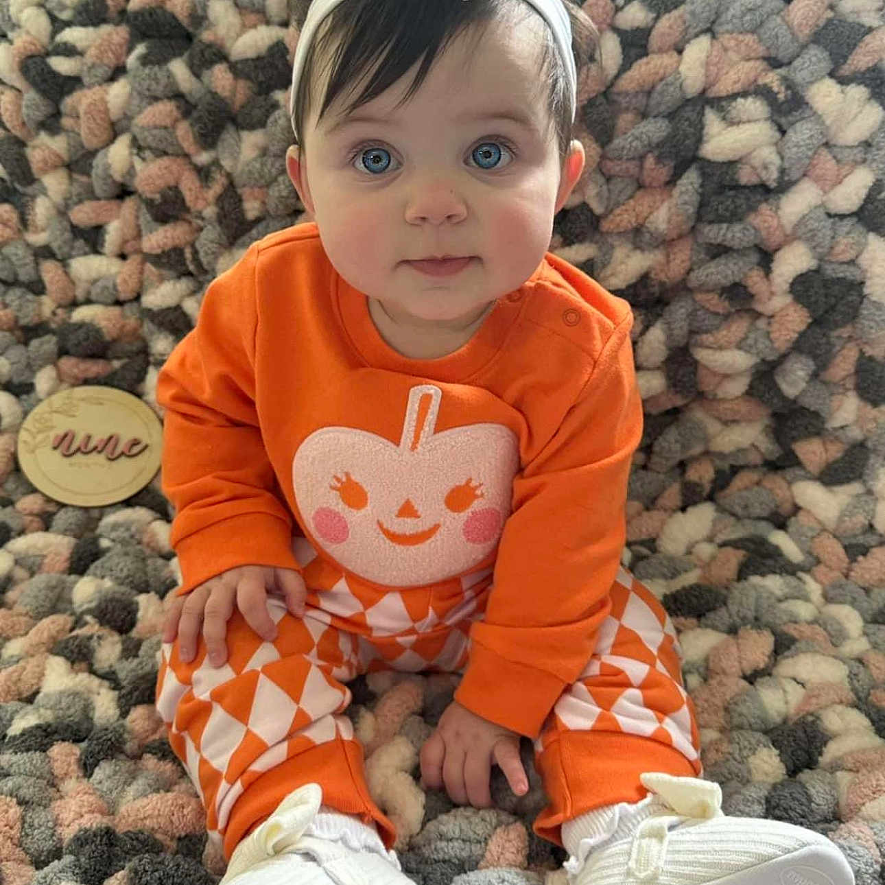 Mila is registered to the contest to win money with this photo: baby, clothing, costume, dress, face, footwear, hair, head, jeans, pants, pebble, person, photography, portrait, road, rock, shoe, sitting, sleeve, sneaker