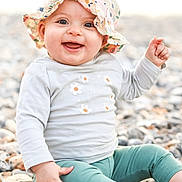 Lily participe au concours pour gagner de l'argent avec cette photo : baby, barefoot, child, closeup, cute, daylight, floral_hat, happy, hat, infant, joyful, leggings, long_sleeve_shirt, nature, outdoor, pebbles, playful, portrait, sitting, smiling