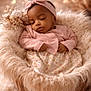 baby, infant, sleeping, basket, blanket, headband, floral_blanket, bokeh, heart_bokeh, plush, cozy, newborn, portrait, soft_lighting, peaceful, pink_outfit, studio_photography, props, fur, closed_eyes