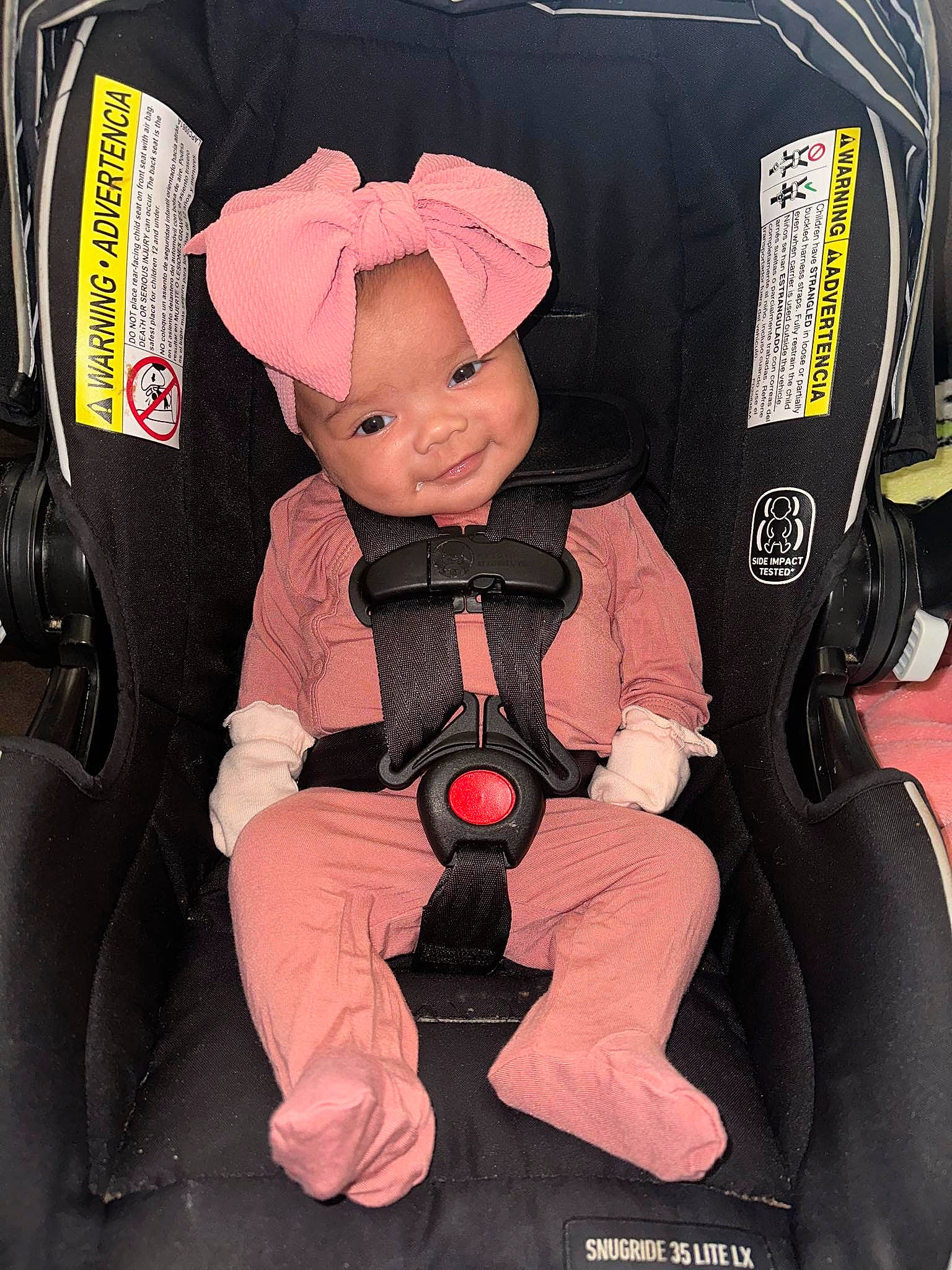 Aspen is registered to the contest to win money with this photo: auto_part, baby, baby_carriage, baby_products, baby_safety, baby_toddler_clothing, bag, baggage, car_seat, car_seat_cover, carmine, child, comfort, headwear, lap, motor_vehicle, person, personal_protective_equipment, pink, sitting