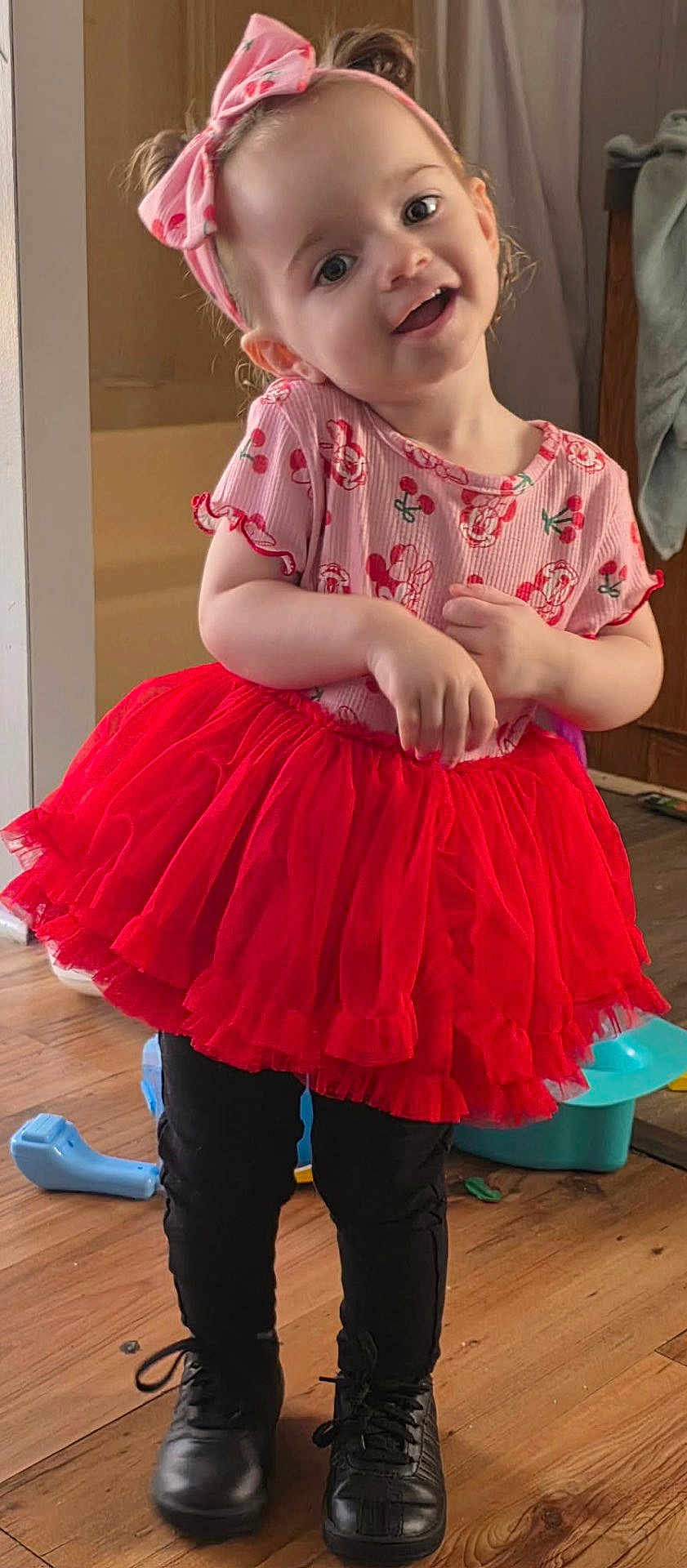 Olivia joined the competition — help win amazing prizes! child, toddler, girl, red_tutu, headband, bow, smiling, happy, pink_shirt, black_boots, indoor, wooden_floor, portrait, cute, pose, playful, toy_in_background, short_hair, big_eyes, casual_clothing