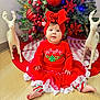 Thaizary joined the competition — help win amazing prizes! baby, child, christmas_tree, holiday, red_clothing, headband, bow, reindeer_statue, floor, festive, decoration, ornaments, tulle_skirt, striped_pants, indoors, smiling, cute, celebration, seasonal, happy