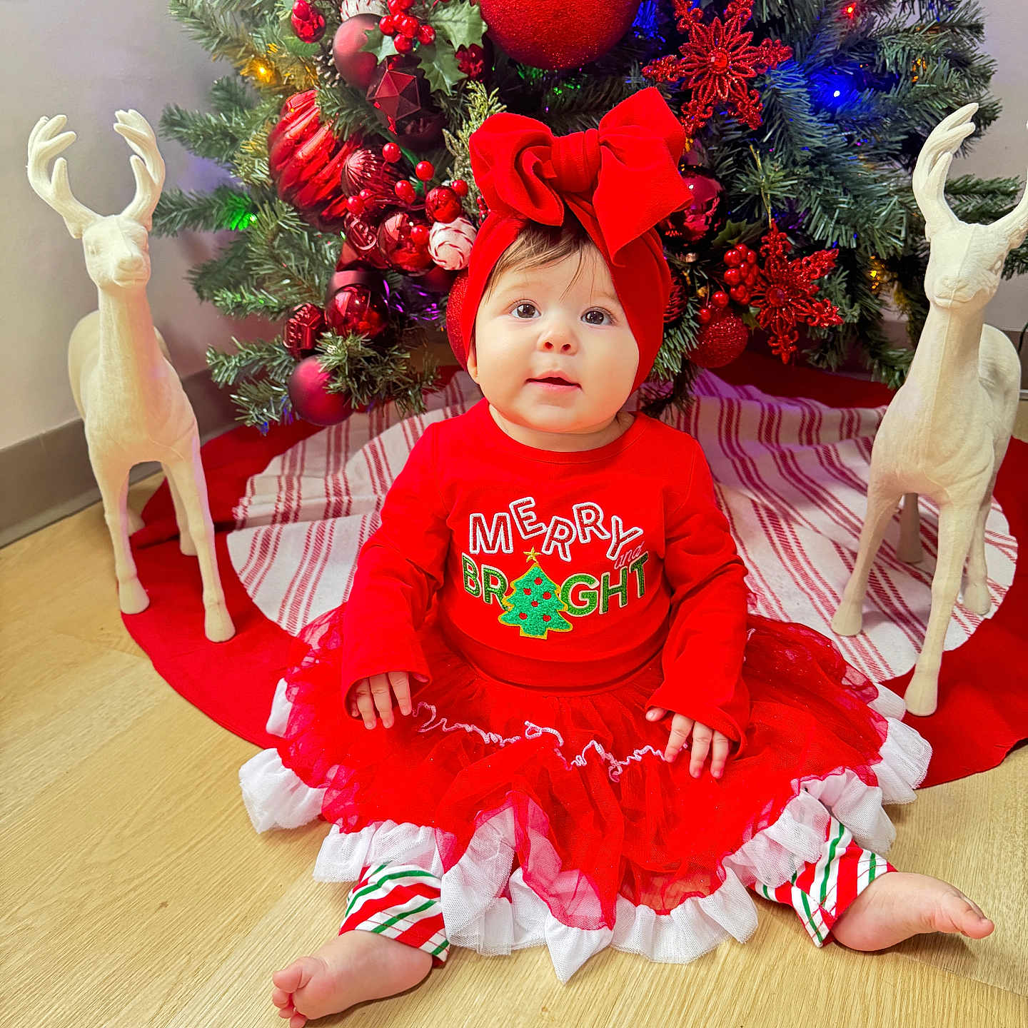 Thaizary joined the competition — help win amazing prizes! baby, bow, celebration, child, christmas_tree, cute, decoration, festive, floor, happy, headband, holiday, indoors, ornaments, red_clothing, reindeer_statue, seasonal, smiling, striped_pants, tulle_skirt