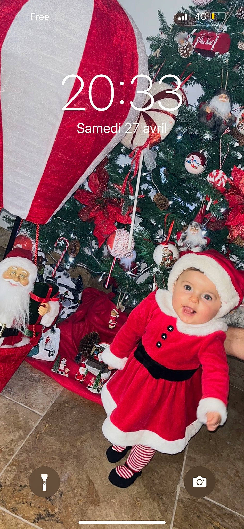 Iris participe au concours pour gagner de l'argent avec cette photo : baby_toddler_clothing, christmas, christmas_decoration, christmas_eve, christmas_ornament, christmas_tree, event, fictional_character, happy, hat, headwear, holiday, holiday_ornament, interior_design, ornament, person, pink, red, santa_claus, smile