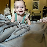 Cali is registered to the contest to win money with this photo: baby, smiling, indoors, blanket, crawling, dimples, face, child, happy, furniture, clothing, room, portrait, head, person, carpet, home, cute, infant, expression