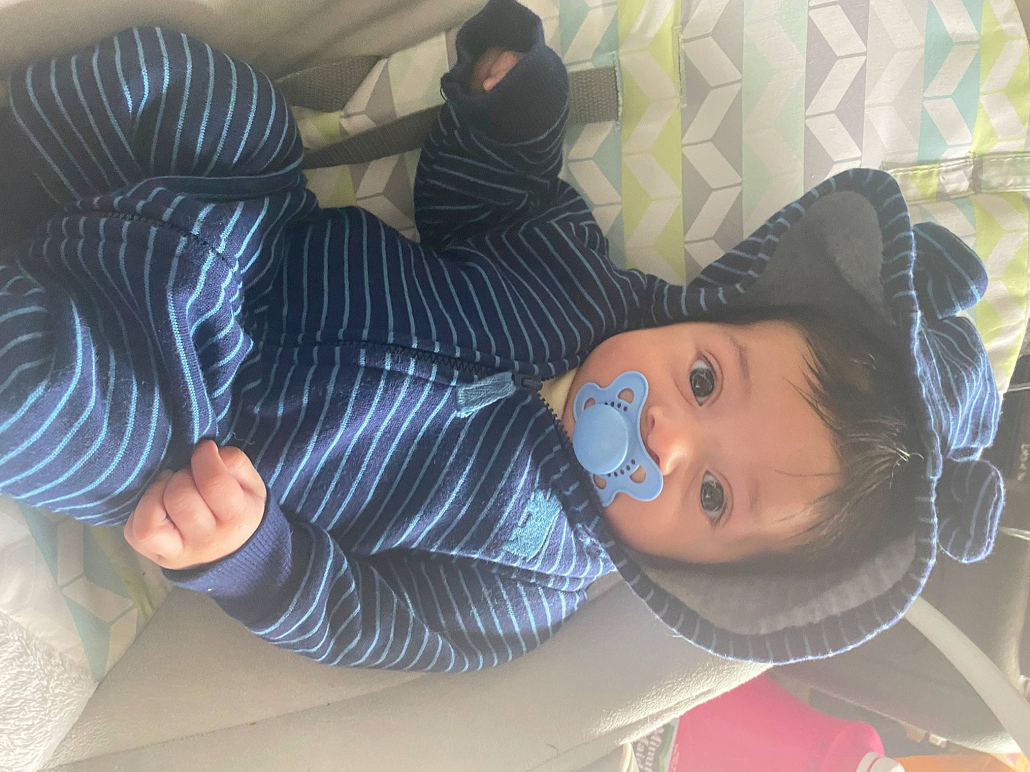 Ezra is registered to the contest to win money with this photo: baby, child, comfort, eyelash, finger, fun, hat, headgear, human_leg, lap, person, room, sitting, sun_hat, textile, thigh, thumb, toddler, tree