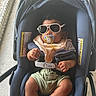 accessory, baby, bib, car_seat, child, clothing, cute, face, footwear, hand, indoor, infant, pacifier, person, relaxing, seat_belt, shade, socks, summer, sunglasses