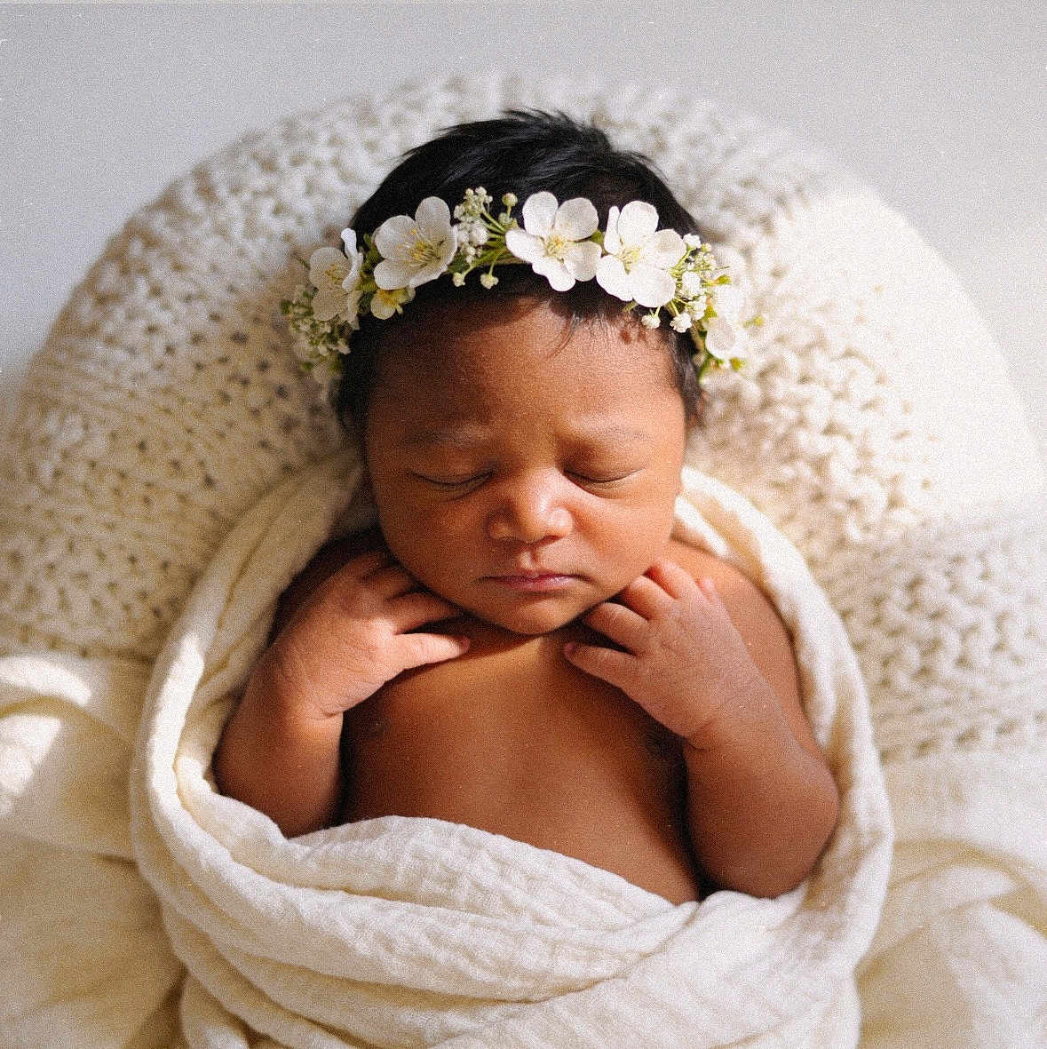 Eastlynn is registered to the contest to win money with this photo: baby, newborn, sleeping, flower_crown, blanket, knitted_cushion, soft_light, skin, peaceful, infant, portrait, closeup, indoors, child, cute, wrapped, hands, head, rest, cozy