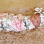 Eastlynn is registered to the contest to win money with this photo: baby, sleeping, swaddle, headband, floral_pattern, blanket, soft_texture, infant, cute, peaceful, resting, newborn, cozy, portrait, indoors, child, wrapped, pink, beige, closeup