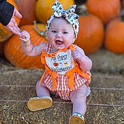 Skadi is registered to the contest to win money with this photo: autumn, baby, bow, celebration, child, cute, festive, footwear, halloween, hand, happy, hay, headband, orange, outdoor, person, pumpkin, seasonal, sitting, smiling