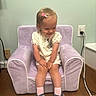 Scarlett Drew is registered to the contest to win money with this photo: toddler, child, purple_chair, sitting, smiling, hair_clip, pink_socks, blue_shoes, minnie_mouse, cute, indoor, carpet, wood_floor, wall_socket, plush_furniture, shorts, short_sleeve, happy, person, young_child