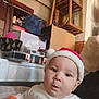 Ezékiel participe au concours pour gagner de l'argent avec cette photo : baby, box, child, clothing, curious, curtain, decor, expression, face, furniture, holiday, indoor, person, santa_hat, shelf, sitting, sleeve, tissue_box, toy, window