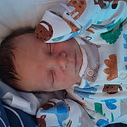 Rhydian-Cole is registered to the contest to win money with this photo: baby, sleeping, newborn, pajamas, animal_print, bed, blanket, soft, face, infant, child, clothing, peaceful, rest, cute, portrait, indoors, cozy, skin, hair