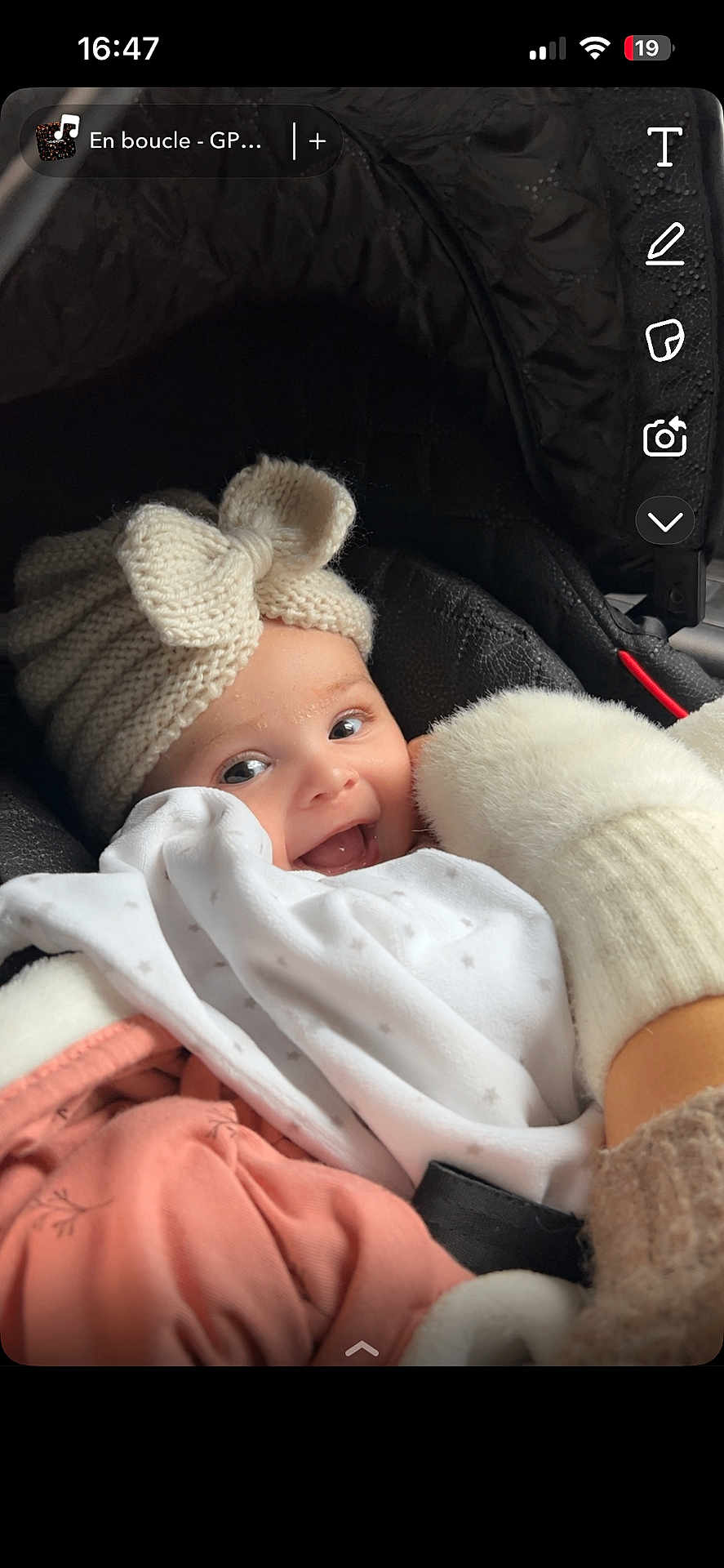 Rym a rejoint le concours — aidez-le/la à gagner de superbes lots ! baby, child, smiling, hat, knitted_hat, bow, car_seat, blanket, winter_clothing, warm, cozy, cute, white_clothing, pink_clothing, infant, face, happy, indoors, person, portrait