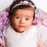 Melya a rejoint le concours — aidez-le/la à gagner de superbes lots ! baby, child, portrait, white_dress, headband, flowers, pearl_necklace, curly_hair, close_up, soft_texture, blanket, pastel_colors, cute, innocent, indoors, smiling, young_child, beautiful, adorable, person
