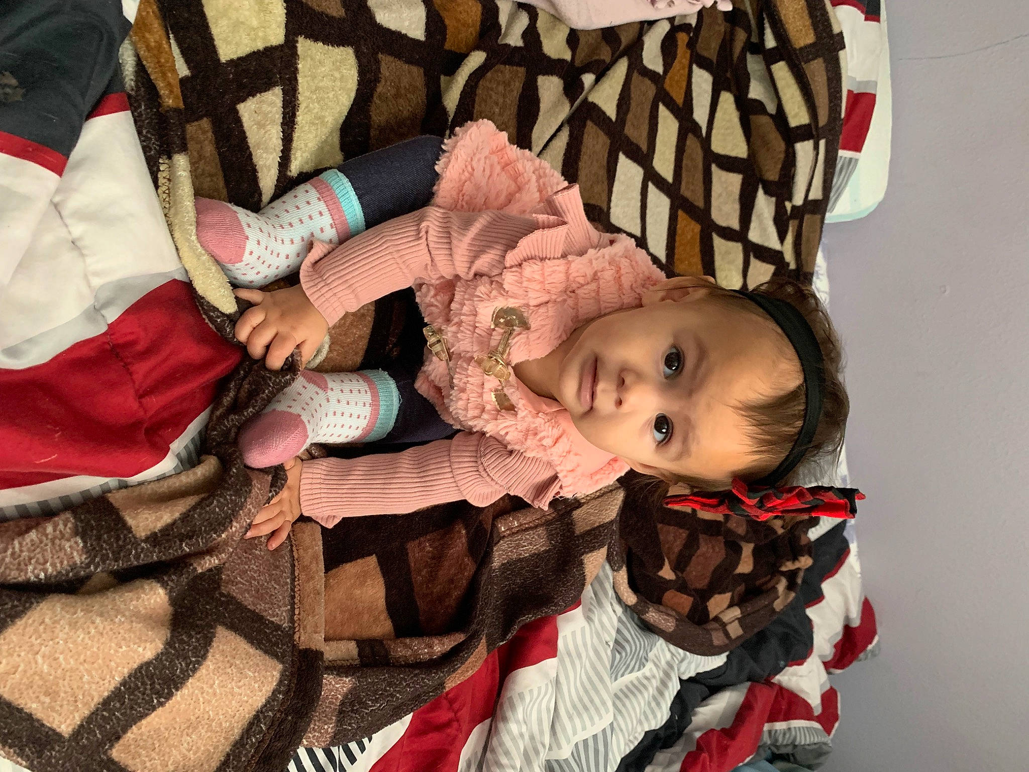 Isabella is registered to the contest to win money with this photo: baby, baby_carriage, baby_products, baby_toddler_clothing, carmine, cheek, child, comfort, eye, fur, human_body, linens, pattern, person, plaid, room, sitting, tartan, toddler, tree